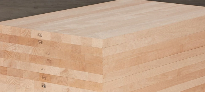 Gestapelte Massivholzplatten mit durchgehenden Lamellen, ideal für den Möbel- und Innenausbau.