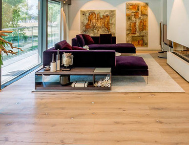 Ein Wohnzimmer mit moderner Einrichtung und einem Kamin, dessen Boden mit Eichen-Rustikal-Laminat verlegt ist.