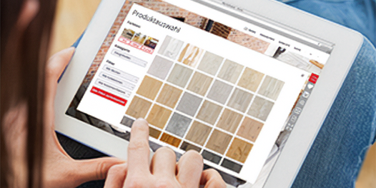 Eine Person betrachtet Holzfarbmuster auf einem Tablet mit geöffnetem Raumplaner.
